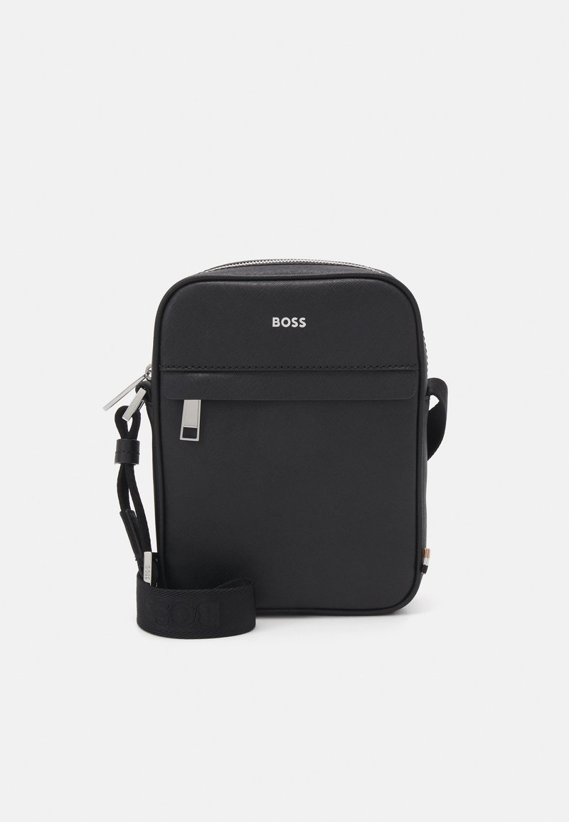 Černá syntetická crossbody taška se zipovým uzávěrem, přední kapsou a nastavitelným popruhem, na kterém je na přední straně logo značky "BOSS".