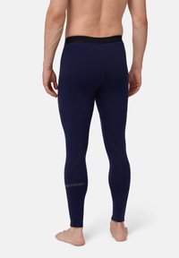 Marina termobyxor med en slät yta, elastisk midja och vit logodetalj vid underbenet. Kroppsnära design.