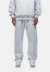 Grijze hoodie met een voorzak en bijpassende grijze sweatpants met een elastische tailleband. Bevat een klein logo op de broek.