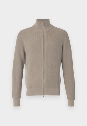 Suéter beige acanalado con cuello alto y cremallera frontal. Cuenta con mangas largas y un acabado texturizado, adecuado para usar en capas.