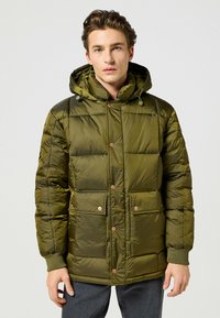 Zielona pikowana kurtka z kapturem, z zatrzaskami, ściągaczami na rękawach i dwoma przednimi kieszeniami. Gładki, błyszczący materiał z przeszyciami.