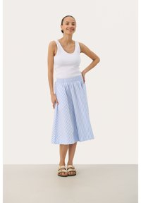 White ribbed tank top with a blue and white striped midi skirt, featuring an elastic waistband and A-line silhouette. Worn with beige sandals.