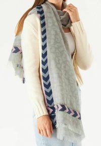 Grau gemusterter Schal mit Tierdruck, akzentuiert mit marineblauem, pinkem und grünem Zickzackstreifen. Strukturiertes Gewebe mit fransigen Kanten.