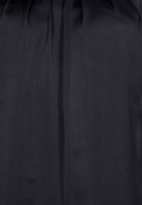 Czarna satynowa sukienka o gładkiej strukturze, z delikatnymi fałdami i prostym krojem. Bez widocznych wzorów ani detalów sprzętowych.