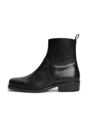 Bottine en cuir noir à talon bas, languette latérale et coutures discrètes, vue de la face extérieure.