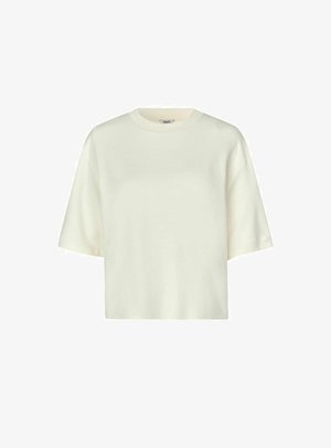 Lühikeste varrukatega, ümarate kaelustega t-särk kreemjas värvitoonis. Valmistatud pehmest kangast, millel on lõdvestatud lõige ja lihtne disain, ilma nähtavate mustrite või aktsentideta.