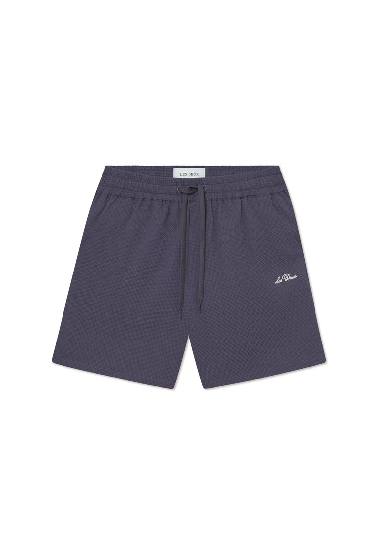 Pantaloni scurți bleumarin dintr-un material texturat, cu o talie elastică și un șnur pentru reglare, având un mic logo alb în partea stângă jos a piciorului.