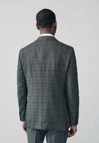 Gray plaid suit jacket with a tailored fit, featuring a notched lapel and single vent. Textured fabric and three-button cuff detail.