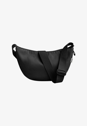 Schwarze Stoff-Schultertasche mit einer geschwungenen Form, verstellbarem schwarzen Tragegurt und dezenten Nähdetails. Sie verfügt über einen Reißverschluss und ein kleines Akzentetikett.