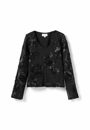 Melnā garo piedurkņu blūze ar V-veida kakla izgriezumu, kurai ir daudzslāņu ziedu izšuvums. Audums ir caurspīdīgs ar gludu tekstūru, kas izceļ sarežģītus rakstus.