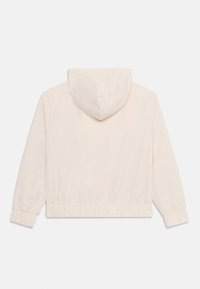 Kremfarget crop hoodie med snorhette, elastisk midje og rynkede mansjetter, laget av myk stoff.