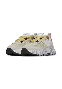 Hellgelbe und weiße Sneakers aus Mesh- und Wildledermaterialien, ausgeprägte schwarze Schnürsenkel und Sohle mit schwarz-weißem Muster. Branding auf der Zunge.