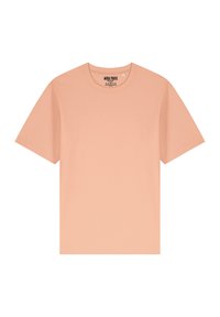 T-shirt en coton couleur pêche avec un col rond, des manches courtes et un design simple. L'étiquette au niveau du col indique "MIRA PARIS."