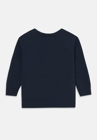 Pull en maille bleu marine avec col rond, manches longues et bord-côtes aux poignets et à l'ourlet ; la texture est lisse avec un motif de point régulier.