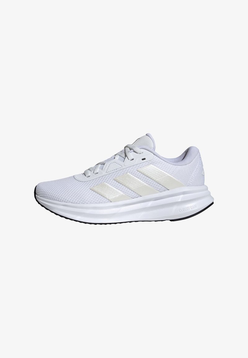 White athletic shoe with mesh upper, three reflective stripes, padded collar, and cushioning outsole. Features textured surface and lace closure.