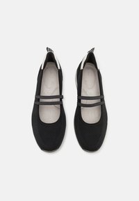 Svart mesh-ballerina med to elastiske stropper over vristen, rund tå og en teksturert såle. Lett polstring på innsiden for komfort.