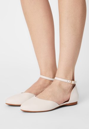 Ballet flat in pelle rosa chiaro, con cinturino alla caviglia e hardware dorato, punta appuntita e suola piatta in legno.
