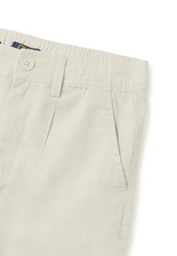 Pantalones cortos de color beige claro hechos de tela tejida. Las características incluyen un frente plano, cintura elástica y bolsillos laterales. Adorno de botón en la cintura.