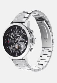 Herre ur i rustfrit stål med en sort skive, chronograph funktioner og flere dagsindikatorer. Sølvfarvet armbånd med polerede led.