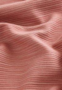 Tejido texturizado en rosa suave y apagado, con acanalado horizontal. Suave, con un ligero brillo y una profundidad de color sutil.