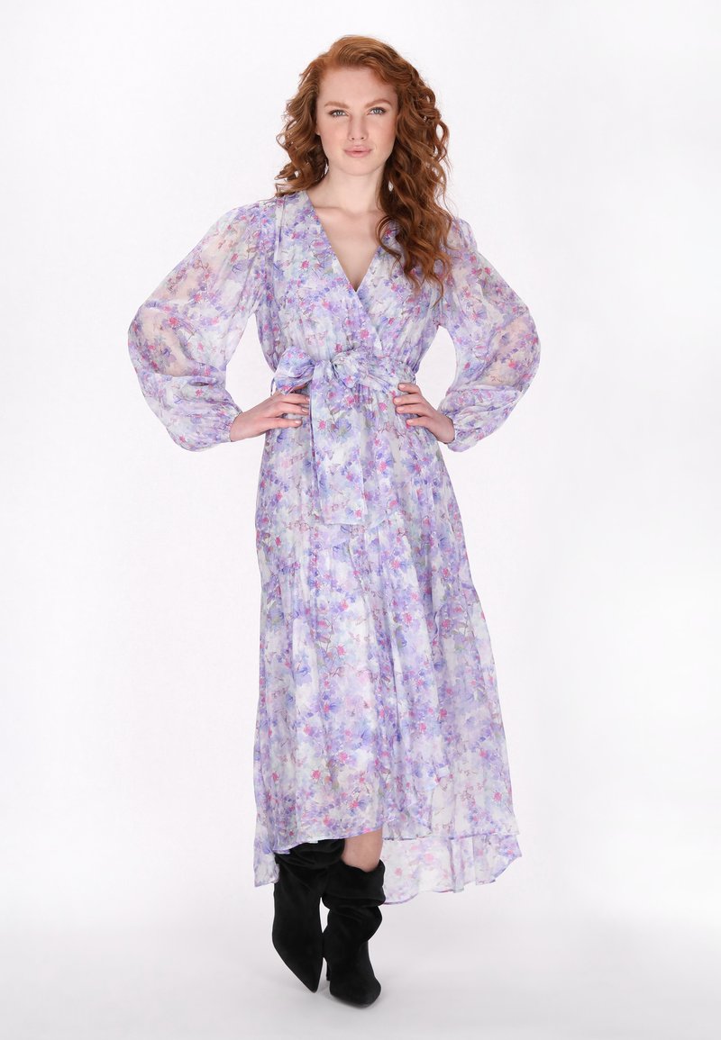 Bloemenprint, lavendelkleurige maxi-jurk van doorschijnende stof, met lange pofmouwen, een wikkelontwerp en een strikceintuur in de taille. Draag het met zwarte kniehoge laarzen.