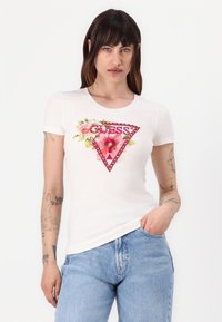 Witte T-shirt met korte mouwen en een bloem- en driehoek grafiek, met het "Guess" logo in het rood en versierd met rhinestones.