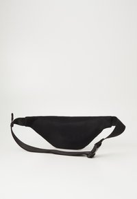 Svart mesh fanny pack med buet design, justerbar stropp og lås, med teksturert overflate og minimalistisk stil.