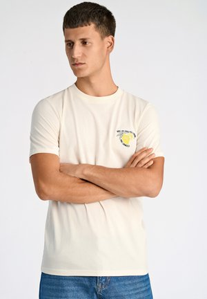 Cremefarvet bomulds t-shirt med korte ærmer, der har et lille gult citron grafik og tekst på venstre brystområde.