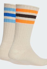 Sociální ponožky po kolena v béžové barvě se třemi horizontálními pruhy: světle modrým, tmavě modrým, oranžovým a černým, s žebrovanou strukturou a jednobarevnými odstíny.