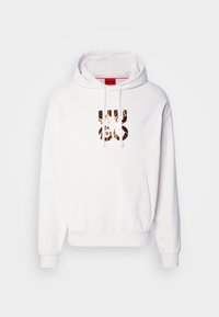 Sudadera blanca con un bolsillo tipo canguro, capucha ajustable con cordones y un gran logo gráfico metálico en la parte frontal. Tela suave con puños y dobladillo acanalados.