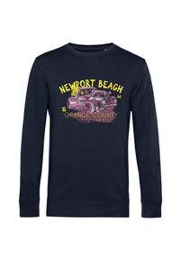 Námořnický svetr s dlouhým rukávem s grafikou vintage auta a nápisy "NEWPORT BEACH" a "ORANGE COUNTY" v žluté a růžové barvě. Měkká tkanina.