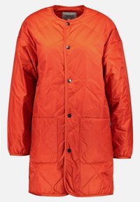 Pikowana pomarańczowa kurtka z okrągłym dekoltem, zapięciem na napy oraz dwiema przednimi kieszeniami. Wykonana z teksturowanej tkaniny dla zapewnienia ciepła i komfortu.