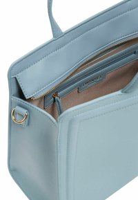 Borsa in ecopelle azzurro chiaro con design strutturato, accessori in oro, scomparto con zip e una superficie liscia. L'interno presenta una tasca.