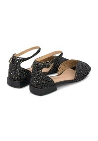Ballerines noires découpées avec bride chevillère, présentant des perforations géométriques, un bout pointu et un talon bas carré. Doublure intérieure lisse.