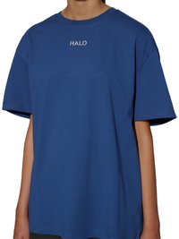 Blå oversized t-shirt med korte ærmer med "HALO" trykt i hvidt centreret nedenfor halsudskæringen, båret af en person.