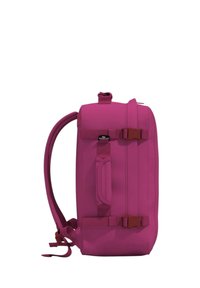 Vaunu vaaleanpunaisella repulla, joka on suorakulmion muotoinen. Varustettu yläkahvalla, säädettävillä sivuolkahvoilla ja näyttävällä solkikiinnityksellä. Teksturoitu kangas.