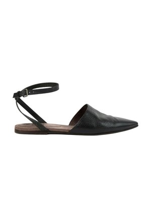 Zwarte leren platte schoen met puntige neus, enkelbandje en open zijkanten op een lichtbruine zool, zijaanzicht op een witte achtergrond.