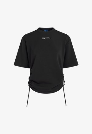 Svart T-skjorte med korte ermer, liten hvit "Karl Lagerfeld Jeans"-logo på brystet og justerbare snorer på sidene ved nederkanten.