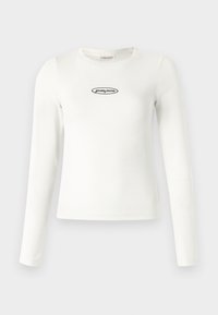 Dlouhý rukáv, bílý vroubkovaný top s přiléhavým střihem, na hrudi s černě vyšitým logem "guess jeans". Měkká bavlněná tkanina.