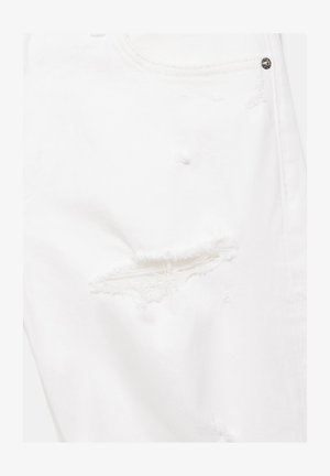 Belo jeansa blago z obrabljeno trganino nad stegno, z raztrganimi robovi in vidnim šivom blizu kovinskega zakovicnega gumba.