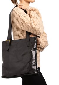 Borsa a spalla in pelle nera con due lunghe cinghie, caratterizzata da una superficie liscia e da una leggera lucentezza. Include un dettaglio con fibbia dorata.