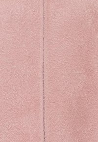 Tessuto rosa morbido con una trama pelosa. Presenta una cucitura verticale al centro, che aggiunge un dettaglio sottile all'intero design.