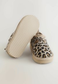 Leopárd mintás csúszócipők bolyhos, texturált felsőrésszel, bézs részletekkel és bordázott gumitalppal a tapadás és kényelem érdekében.