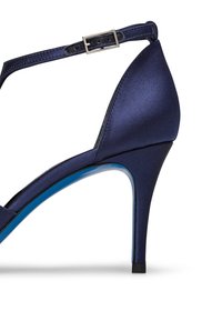 Scarpa con tacco alta in raso blu navy con cinturino alla caviglia, punta affusolata e motivo blu lungo la suola. Texture liscia con una silhouette elegante.