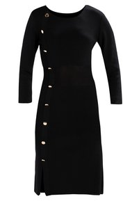 Robe en maille noire à manches longues, col rond, avec un détail de boutons dorés proéminents sur un côté, présentant une fente latérale pour un design supplémentaire.