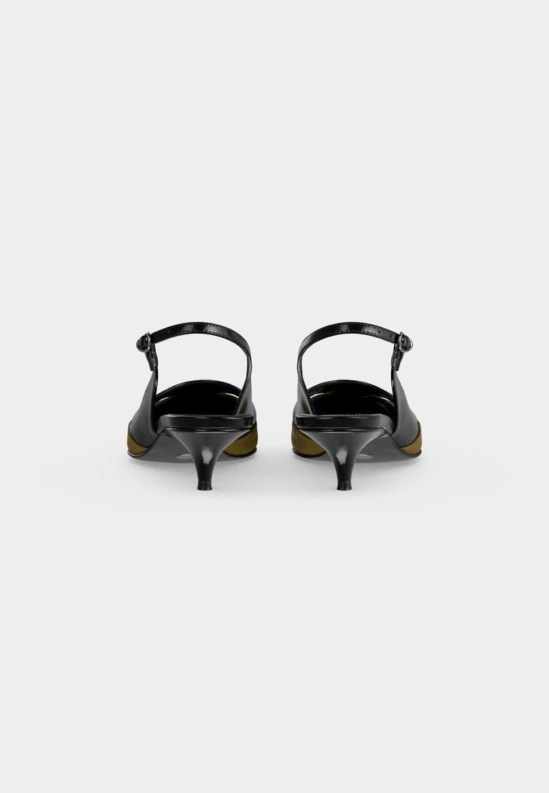 Par sorte dame slingback-sko med smalle stropper og lave kittenhæle, vist bagfra på en ensfarvet baggrund.