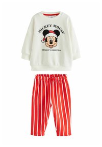 Fehér pulóver, amelyen egy nagy, nyomtatott Mickey Mouse látható, amint Mikulás sapkát visel, piros csíkos nadrággal párosítva, amely rugalmas derékpánttal rendelkezik.