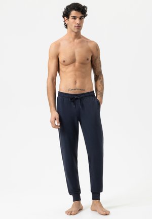 Pantalons de survêtement bleu marine en tissu doux, avec une taille élastique et un lien de serrage, des poignets fuselés et des poches latérales.