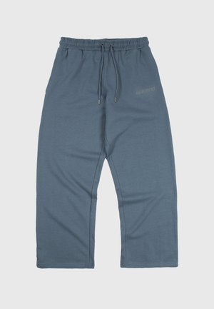 Χαλαρά μπλε-γκρι παντελόνια φόρμας με ελαστική μέση και κορδόνια, με διακριτική λεπτομέρεια κειμένου στο πάνω μέρος του μηρού.