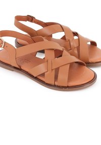 Sandalias de cuero marrón con un diseño entrelazado, una correa ajustable en el tobillo y una suela plana. La parte superior tiene una textura suave.